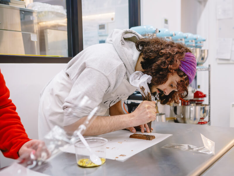 A man decorating a Dubai chocolate bar at a chocolate class